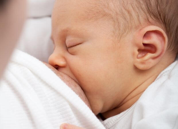 En ammekonsultation kigger på sutteteknikde nyfødt
